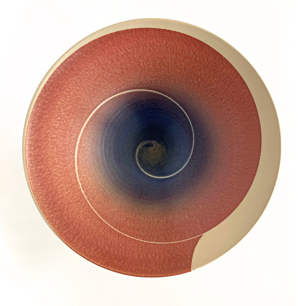 Tapered porcelain bowl with ivory exterior and spiral center design glazed in pink/orange and blue/purple by Wayne Bates at Cottage Curator - Sperryville VA Art Gallery