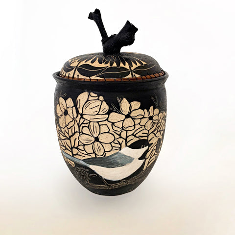 Lidded black and white ceramic vessel with pine needle rim and grapevine lid handle showing a portrait of a chickadee surrounded by plants, carved in sgraffito by Carolyn Blazeck, at Cottage Curator - Sperryville VA Art Gallery