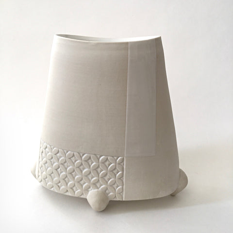 White tapered porcelain vessel with rectangular patches of carved patterns and three feet by Yoshi Fujii at Cottage Curator - Sperryville VA Art Gallery