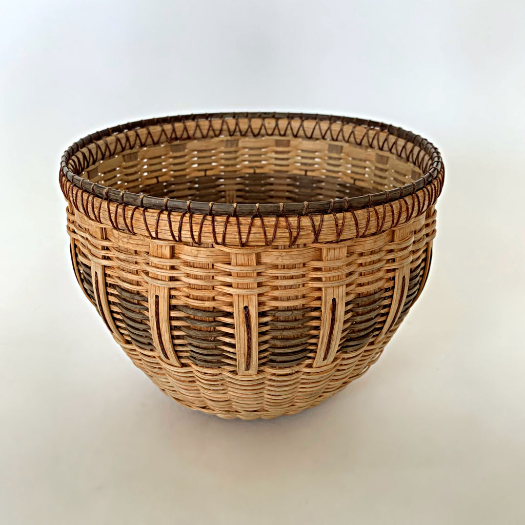 Round woven basket made of white oak in natural and brown patter by Leon Niehues at Cottage Curator - Sperryville VA Art Gallery
